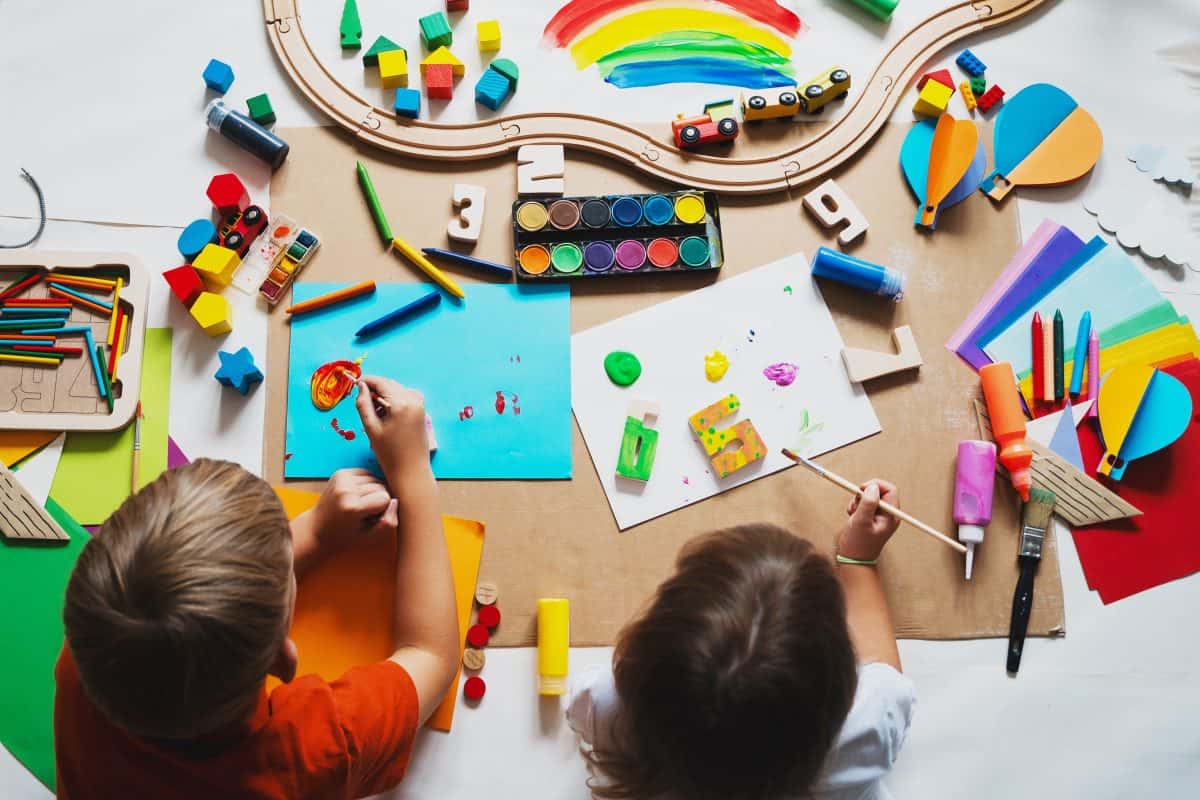 Children drawing and making crafts in kindergarten or daycare. Little kids with educational toys and supplies for creative. Сhildren education and development in preschool or childcare.