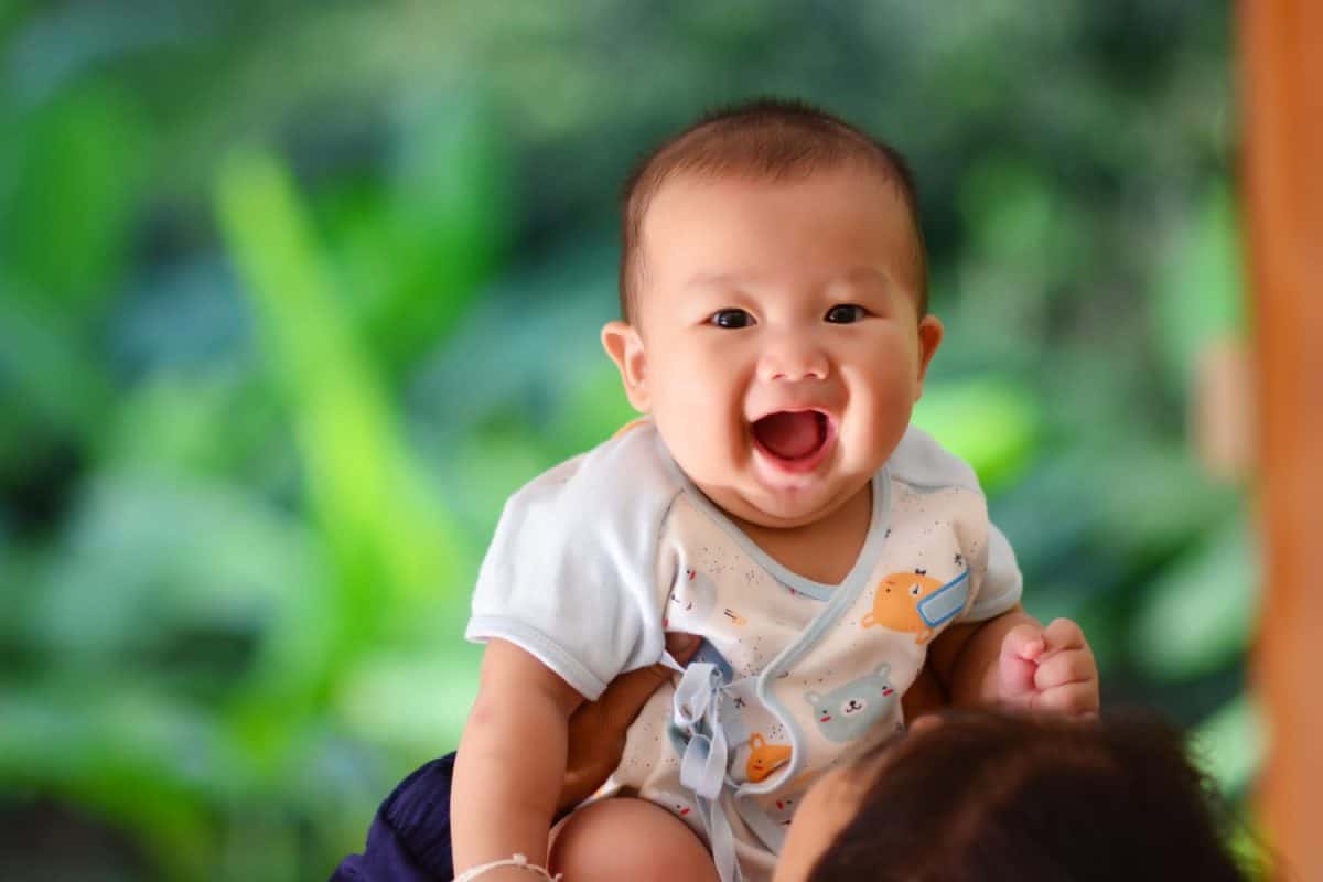 Mother holding funny adorable baby boy and play with her son.