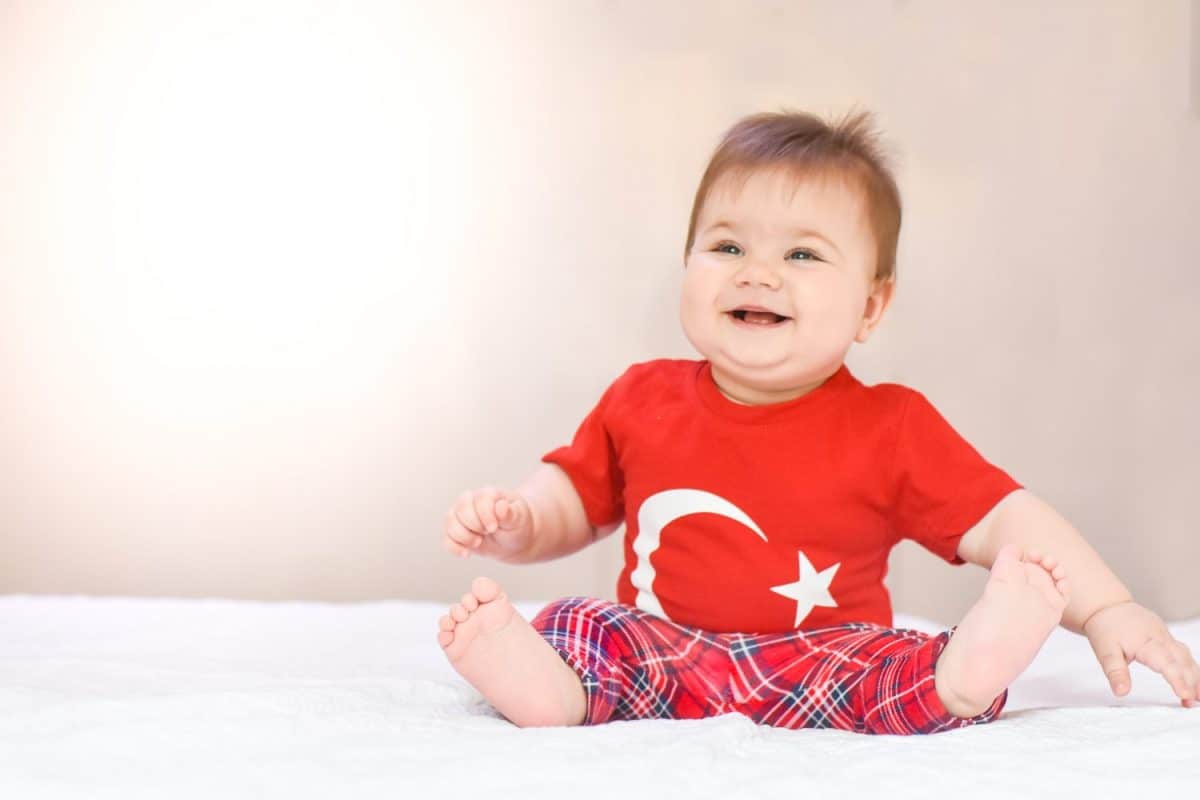 Happy, little kid, cute baby with Turkish flag t-shirt on white background. Patriotic holiday.