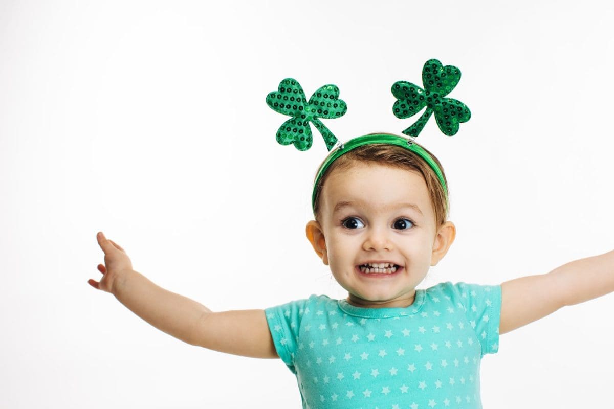 St.Patrick's day clover head decoration on a close up of an excited toddler girl