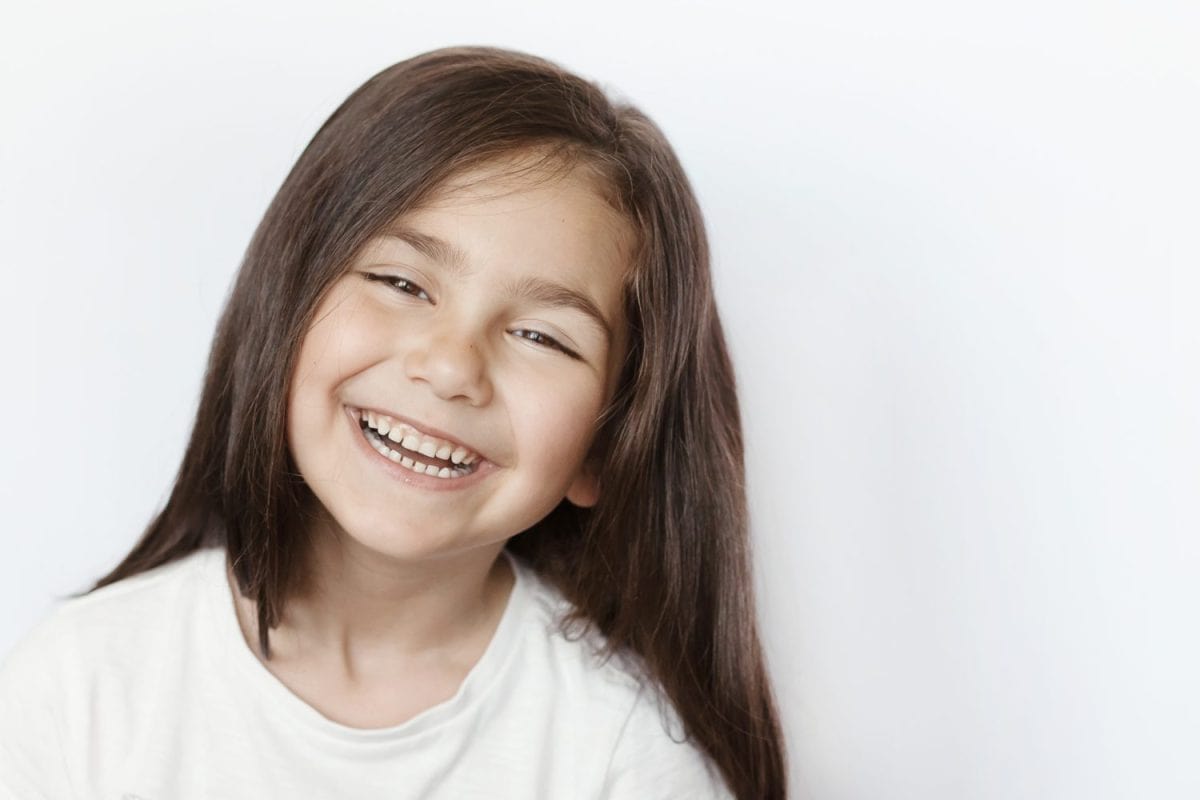 Happy smiling child girl on white background. Childhood concept.