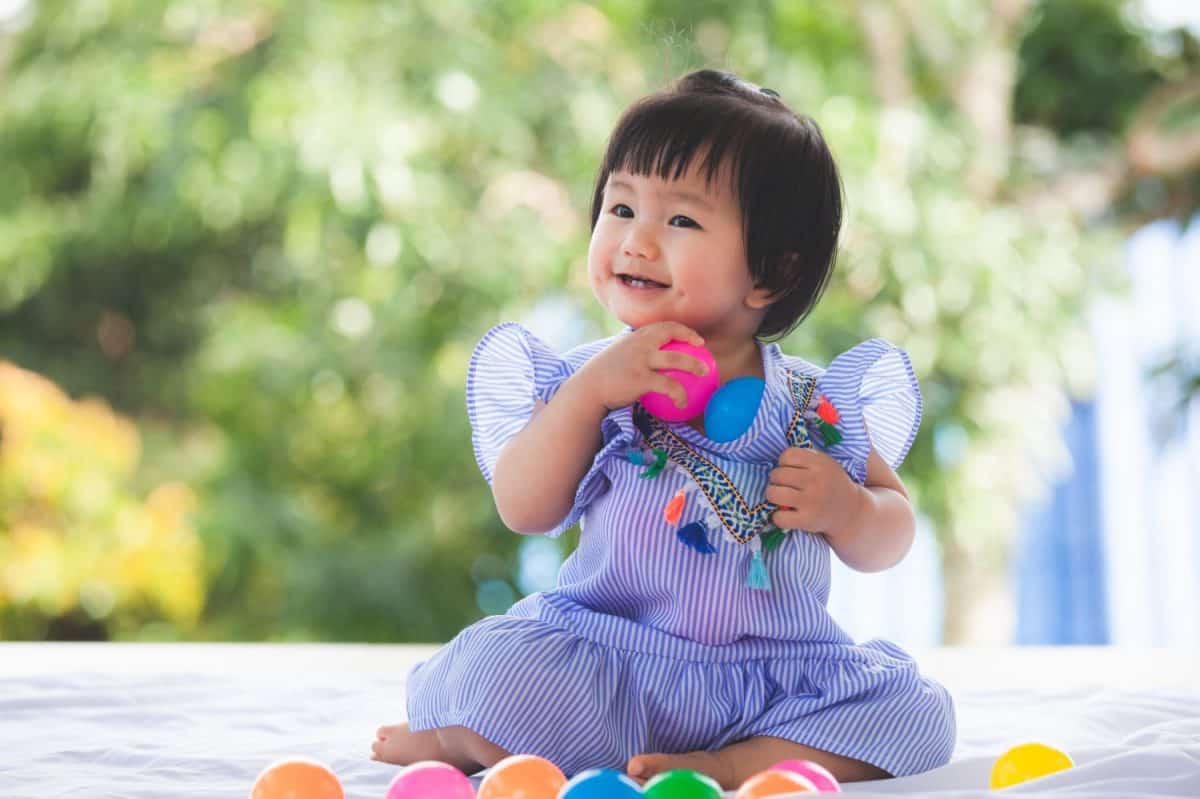 Cute asian baby girl playing with her toy with happiness