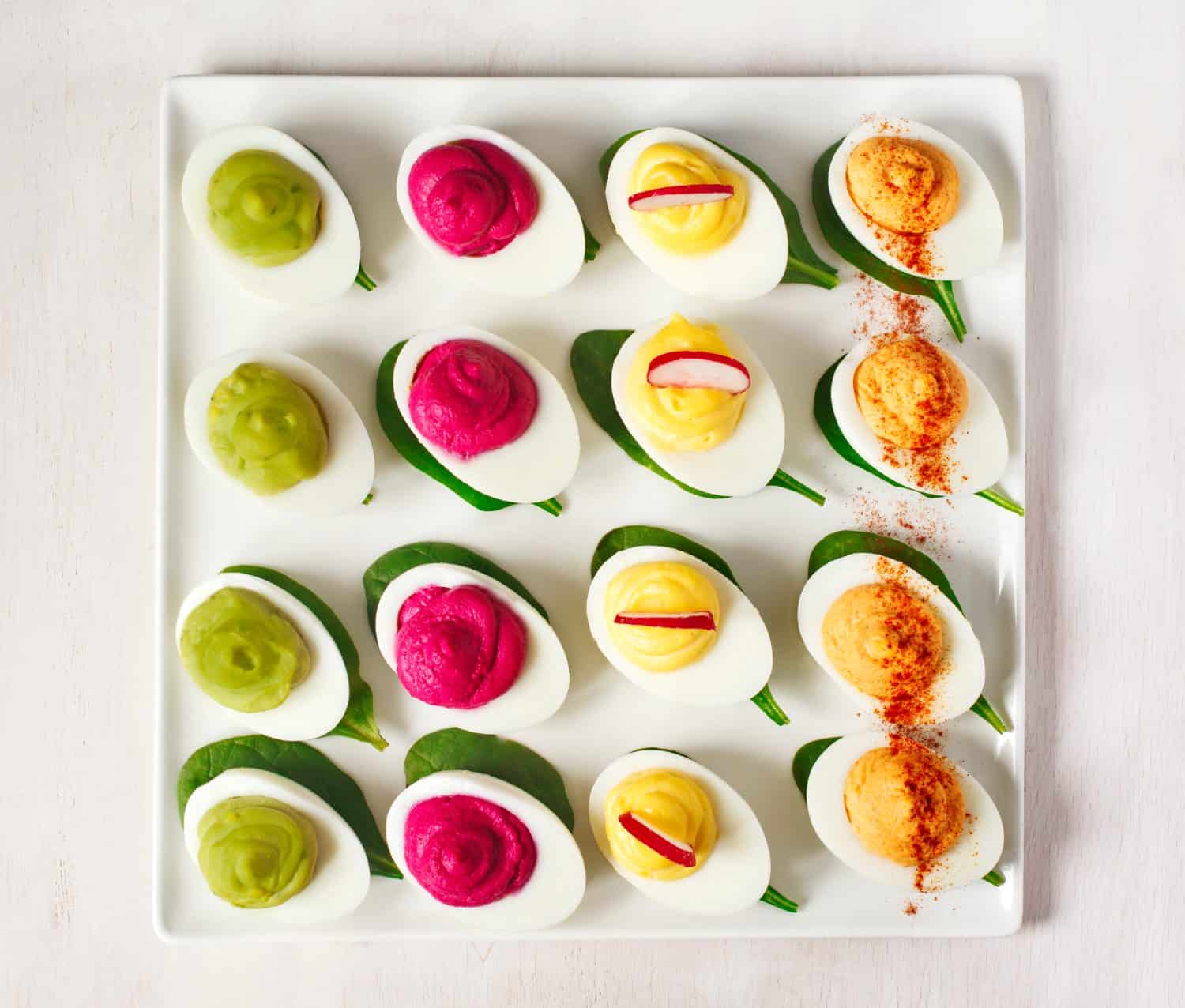 A plate of deviled eggs on dark grey stone background, top view