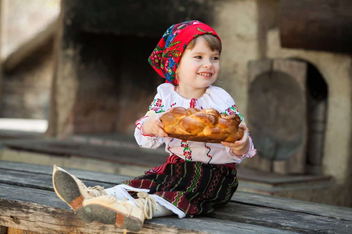 Little girl in traditional Romanian folk costume with embroidery. Girl in Romanian dress. Romanian folklore