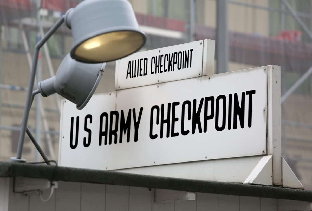 historic signpost in the old border point between East Berlin and West Berlin called Check Point Charlie in use during the Cold War in Europe