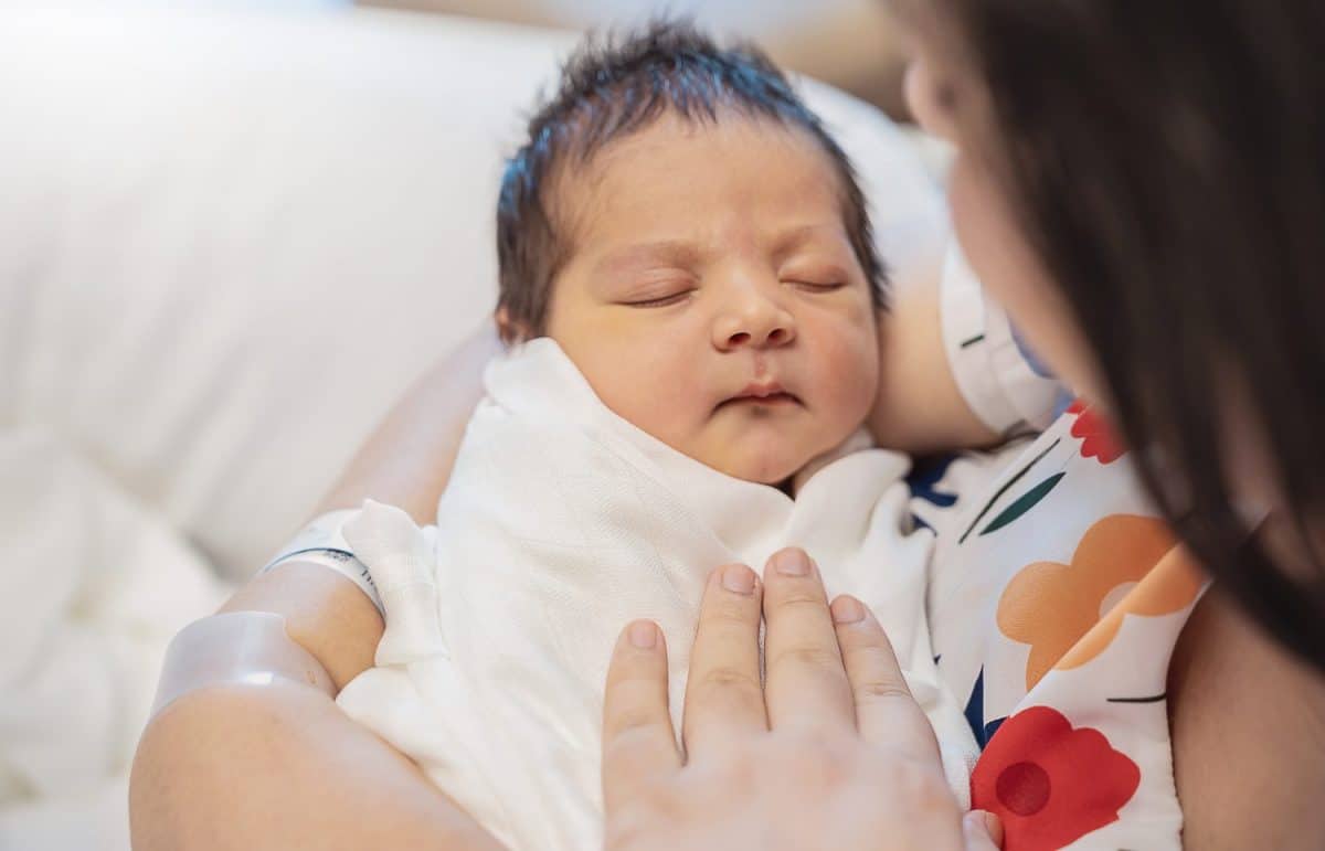 Closeup portrait of young asian Indian mother holding newborn baby with copy space. Healthcare and medical daycare nursery love lifestyle together single mom mother’s day holiday concept