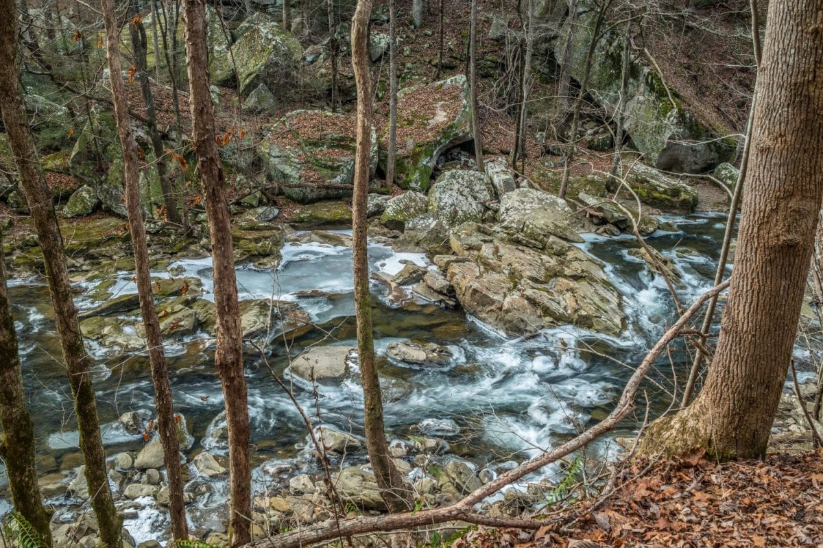 Looking down from the trail at the flowing partially frozen Richland creek in the pocket wilderness in Dayton Tennessee in wintertime