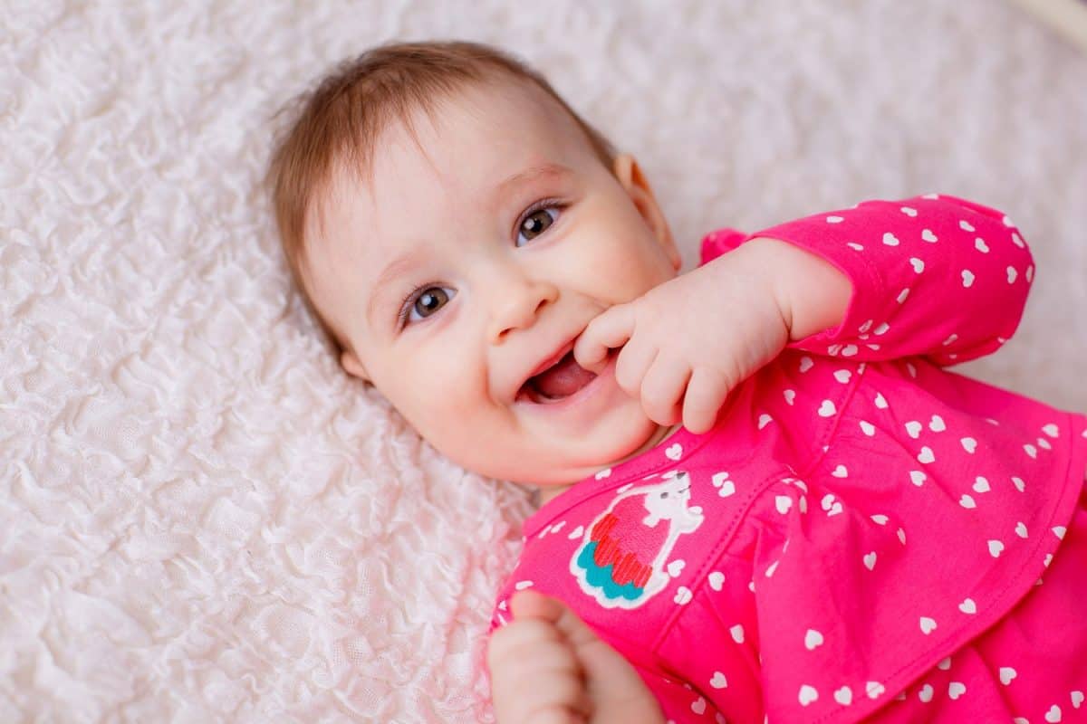 portrait of a beautiful girl. baby lying on the bed. smile