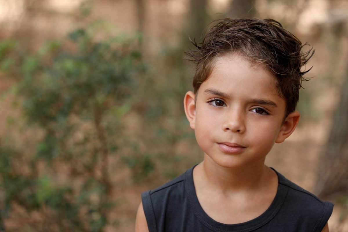 portrait of a 5 year old mixed Italian Brazilian child isolated on a nature background