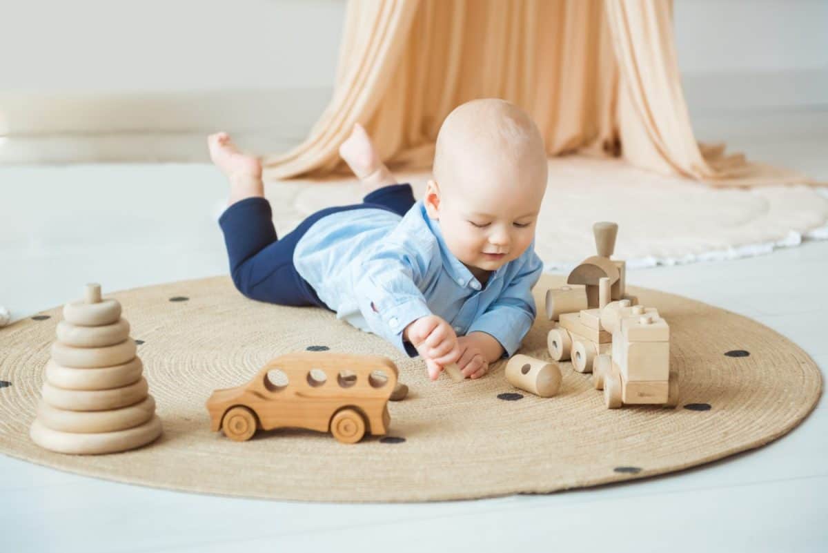 Baby playing with wooden toys. Eco-friendly wooden toys for children