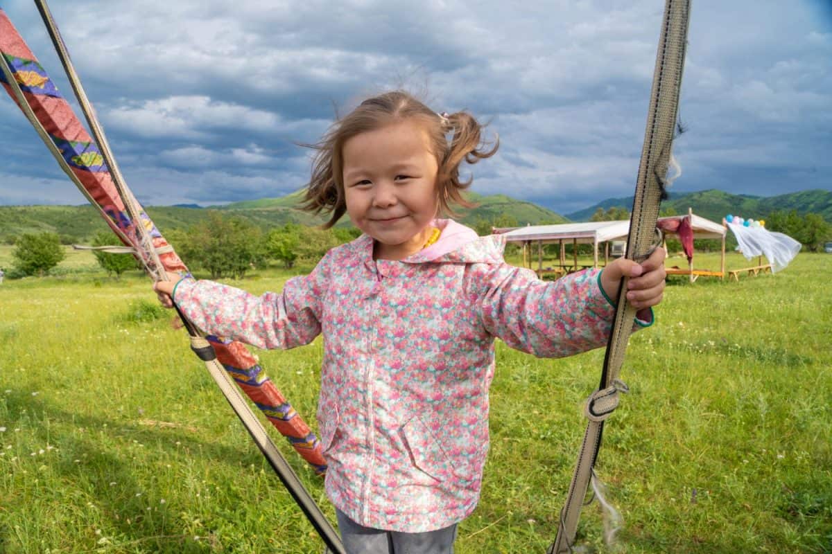 kazakh girl swinging at the national kazakh attraction altybakan