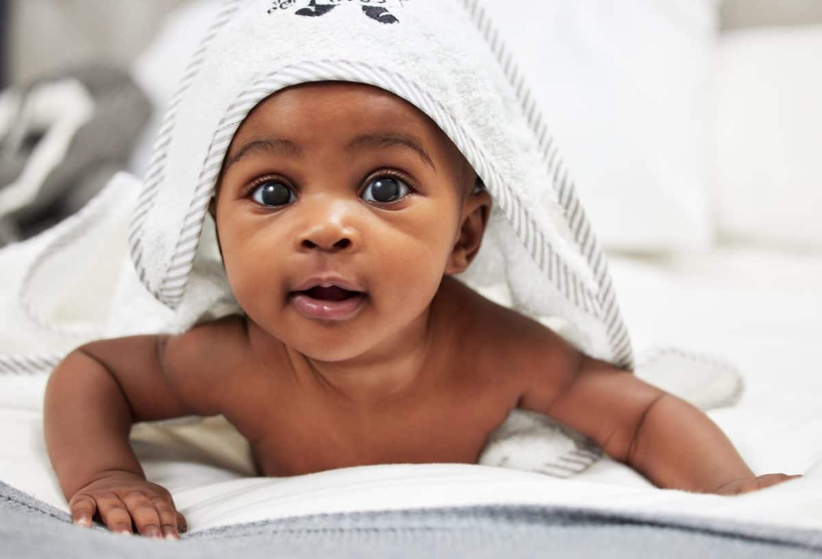 Im ready for my rub. Shot of an adorable baby boy wearing a hoody towel.