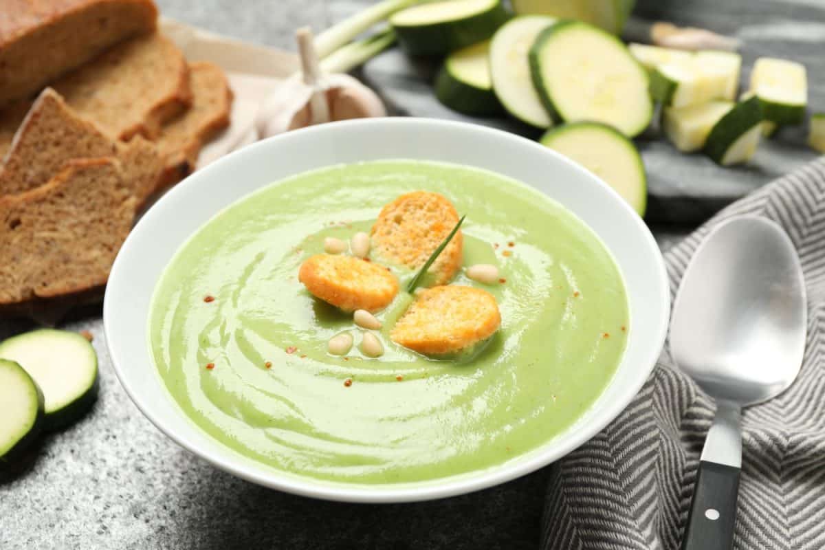 Tasty homemade zucchini cream soup served on grey table