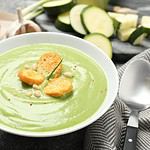 Tasty homemade zucchini cream soup served on grey table