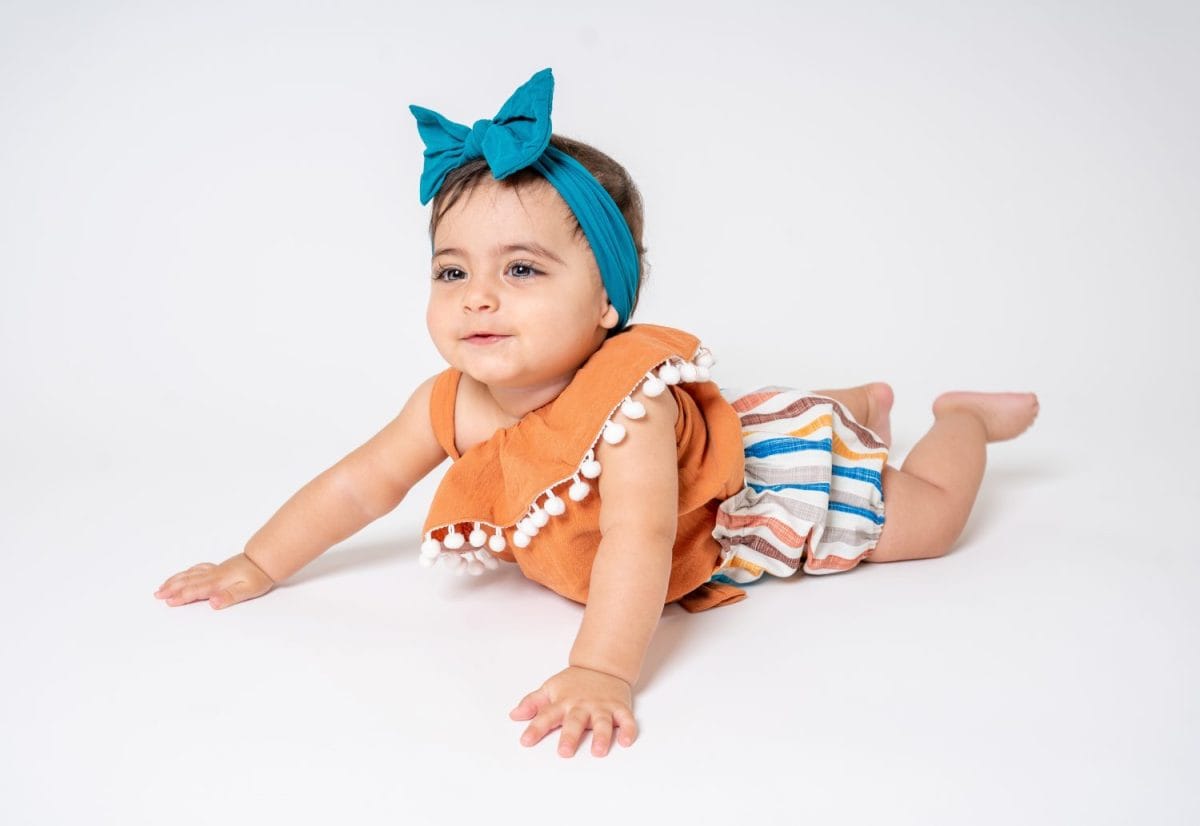 Happy Baby Girl Laying on tummy isolated on a white background