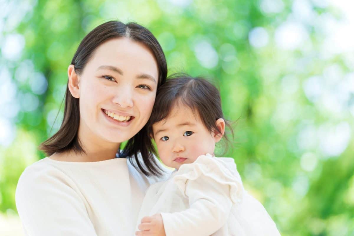 portrait of a young asian mother cuddling her baby on terrace