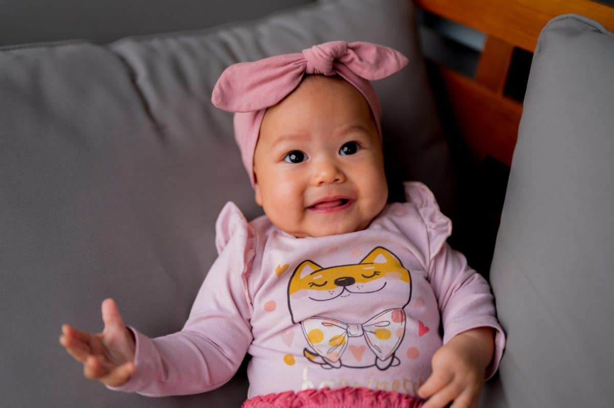 A baby infant girl sitting on the sofa