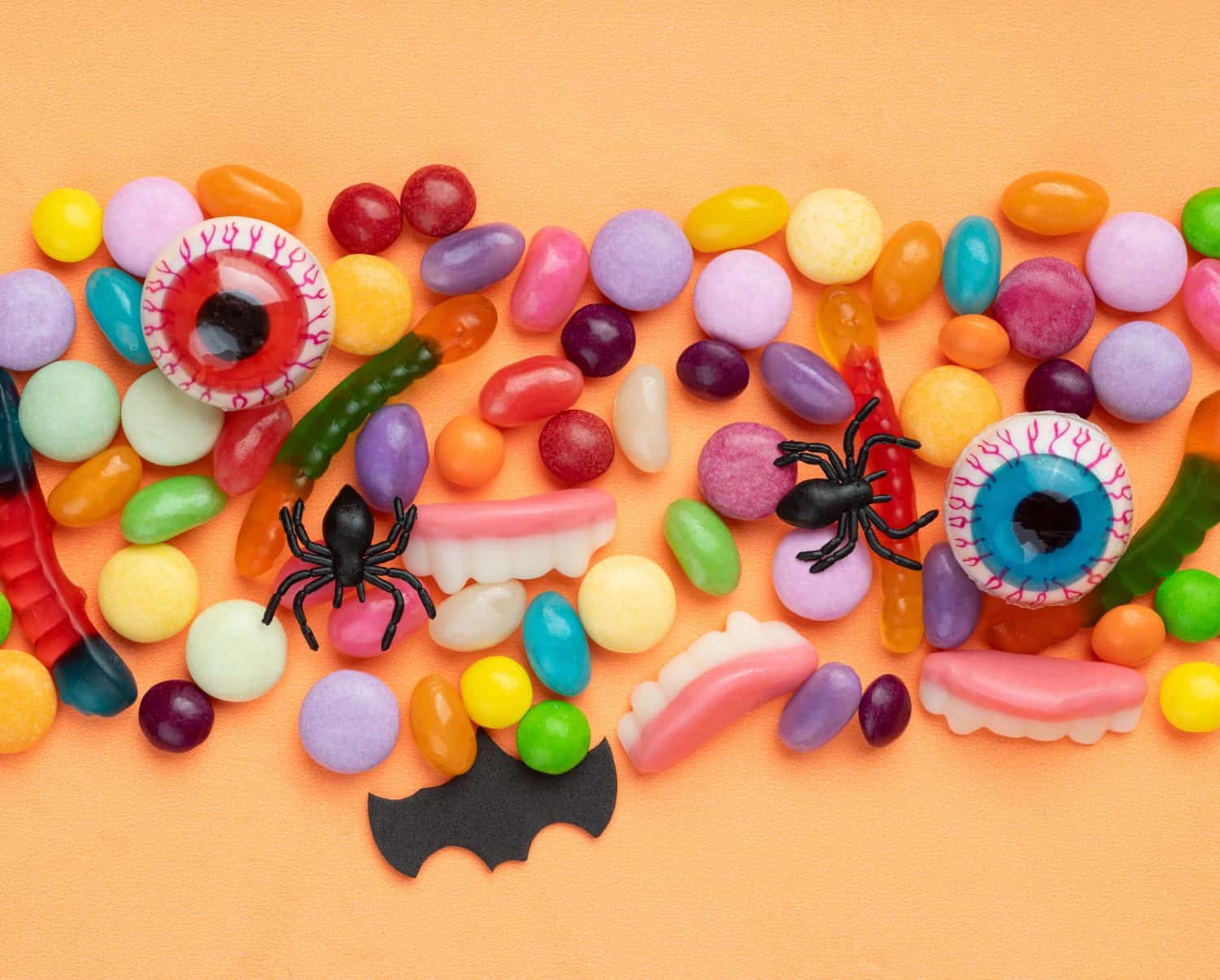 Colorful candies over orange background.