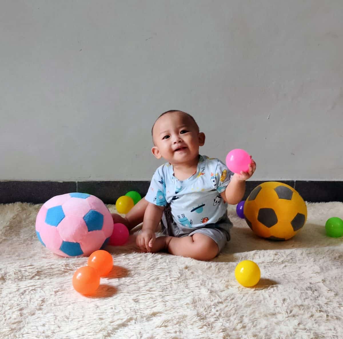 Little baby boy with colorful balls