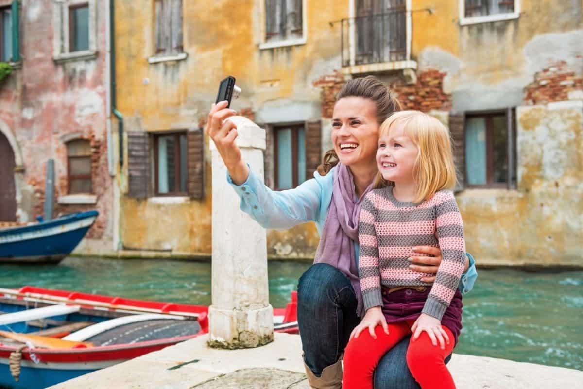 Mother and baby girl making selfie in venice, italy