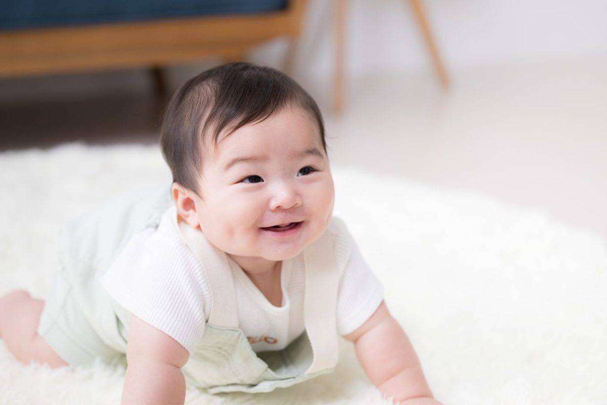 The whole body of a baby with a very precious, happy smile.