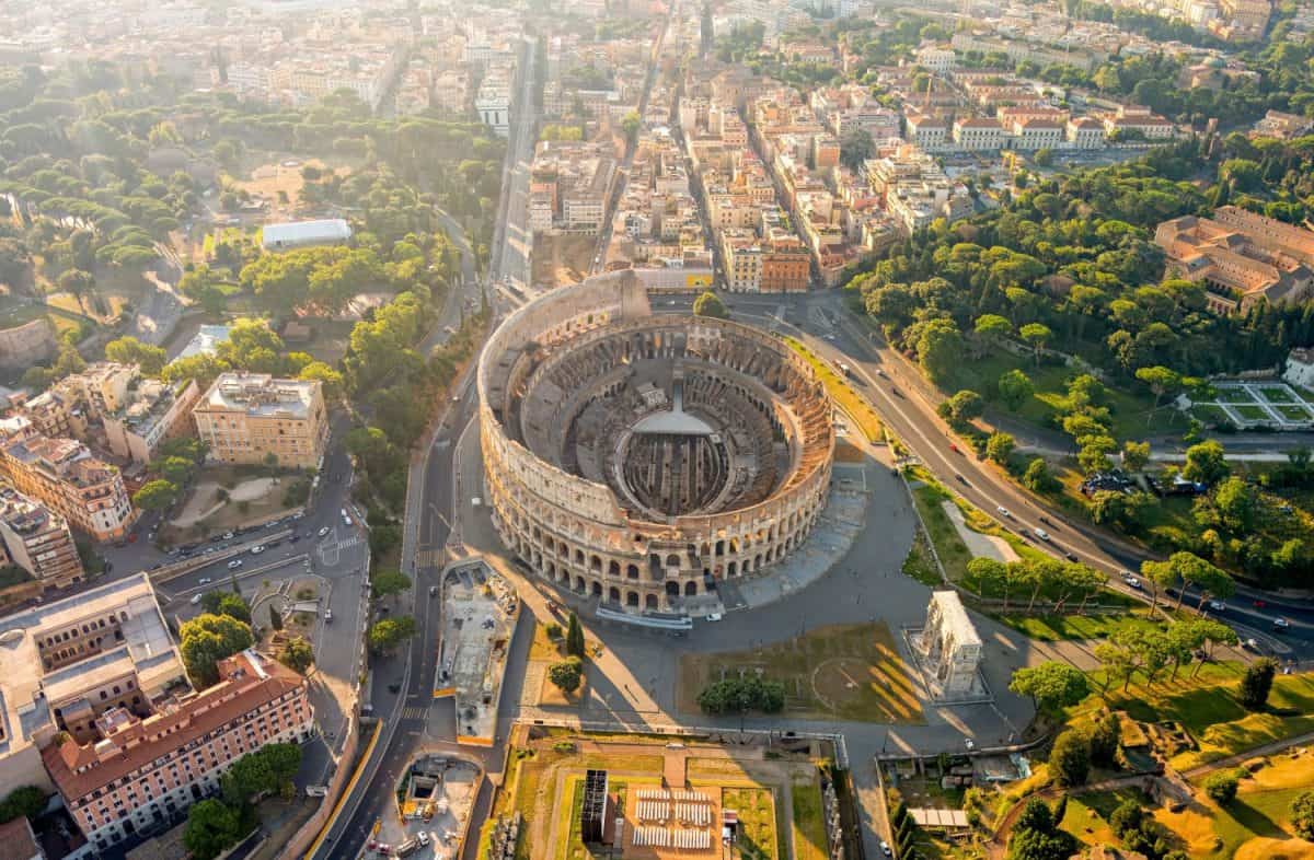 Rome, Italy. Colosseum - A monumental three-level Roman amphitheater where gladiator fights took place. Panorama of the city on a summer morning. Aerial view