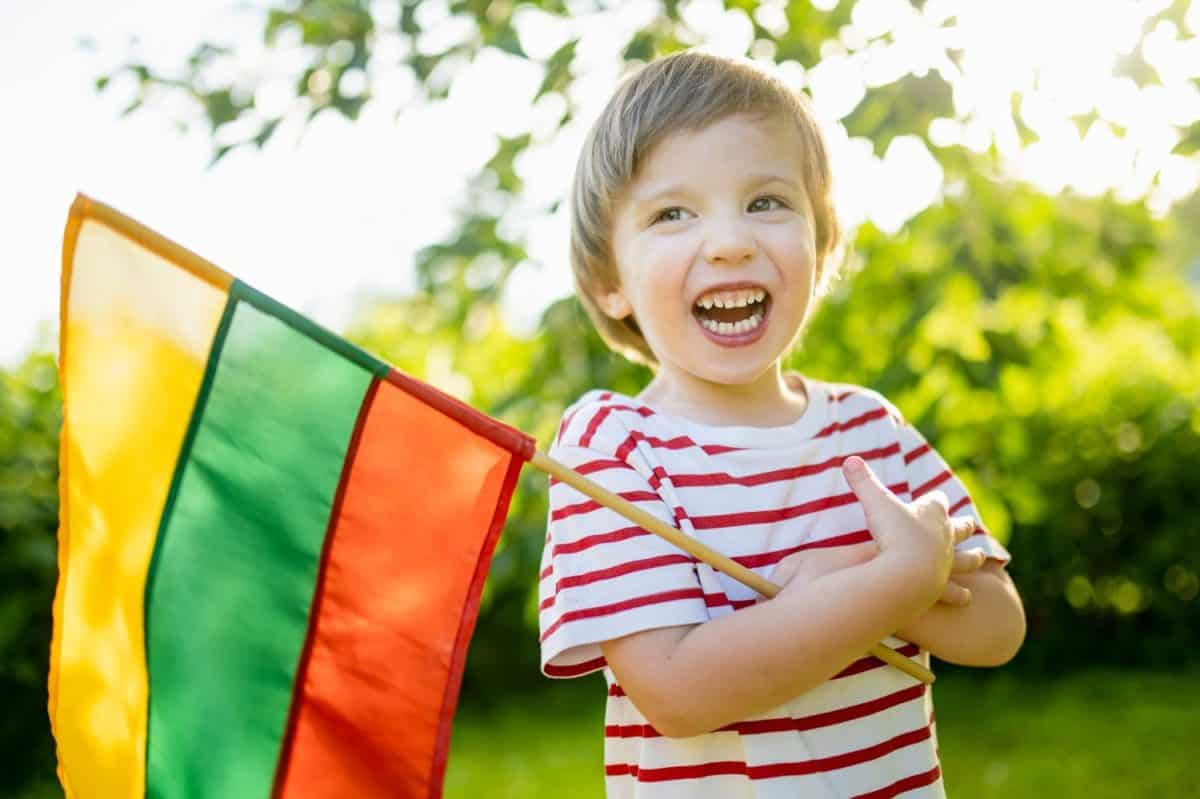 Cute little boy holding tricolor Lithuanian flag on Lithuanian Statehood Day, Vilnius, Lithuania