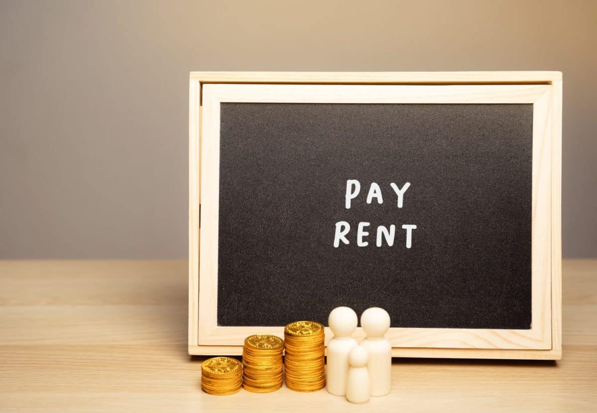 The concept of paying rent for housing, house or apartment. Accumulating money and saving. Miniature family standing near a board with the word pay rent. Things to stop doing once your hit 30