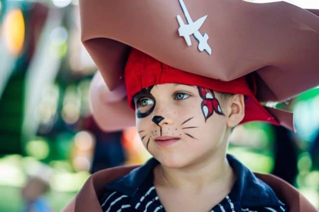 Boy Cat Pirate costume. Halloween party in kindergarten. Aqua makeup painted kids face. Bright festive