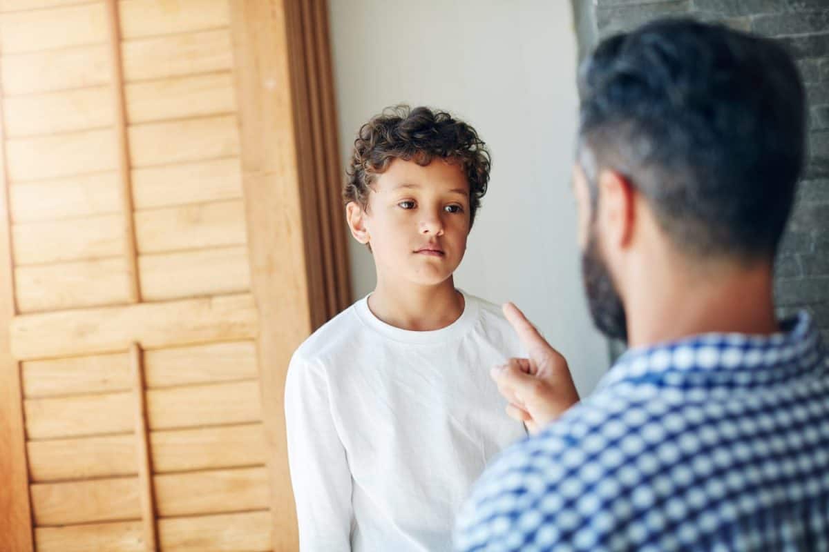 Sorry, dad and discipline child in home with learning a lesson from mistake with psychology. Kid, fail and father teaching son to behavior or frustrated with problem or communication of conflict