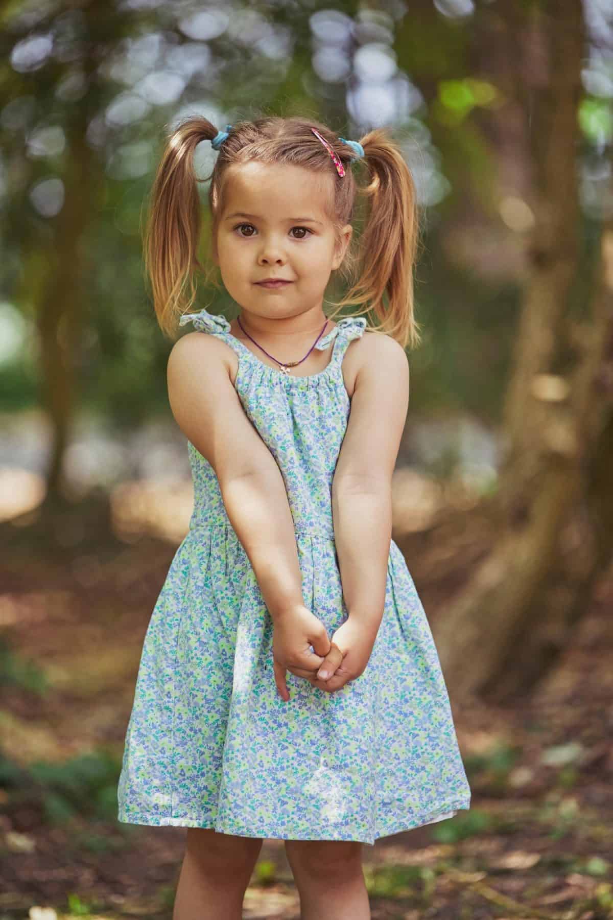 charming child in sundress in the garden