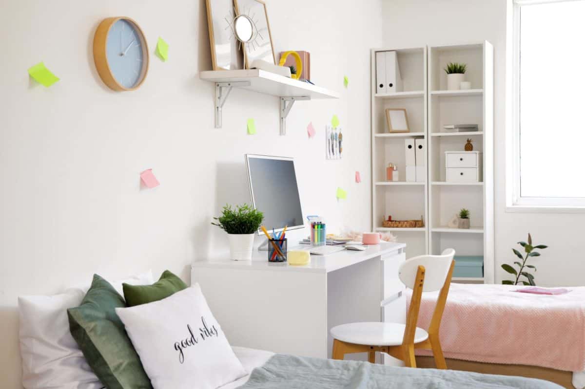 Interior of dorm room with beds, table and sticky notes