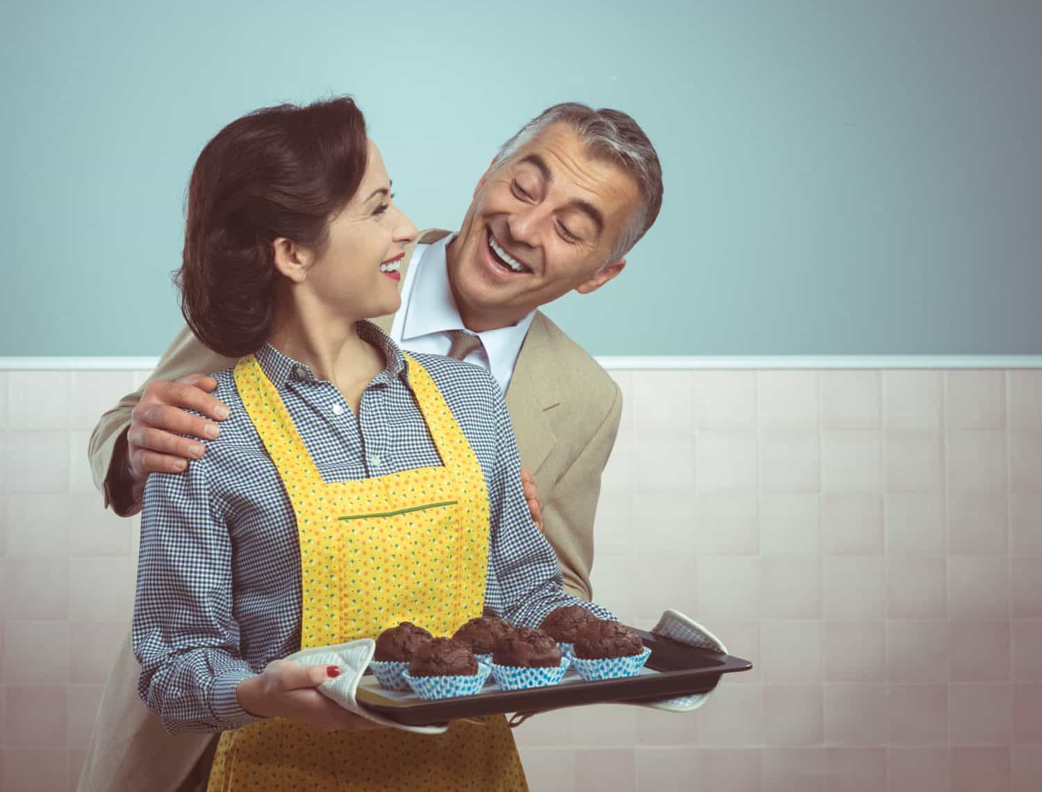 Vintage woman in apron cooking chocolate muffins for her husband