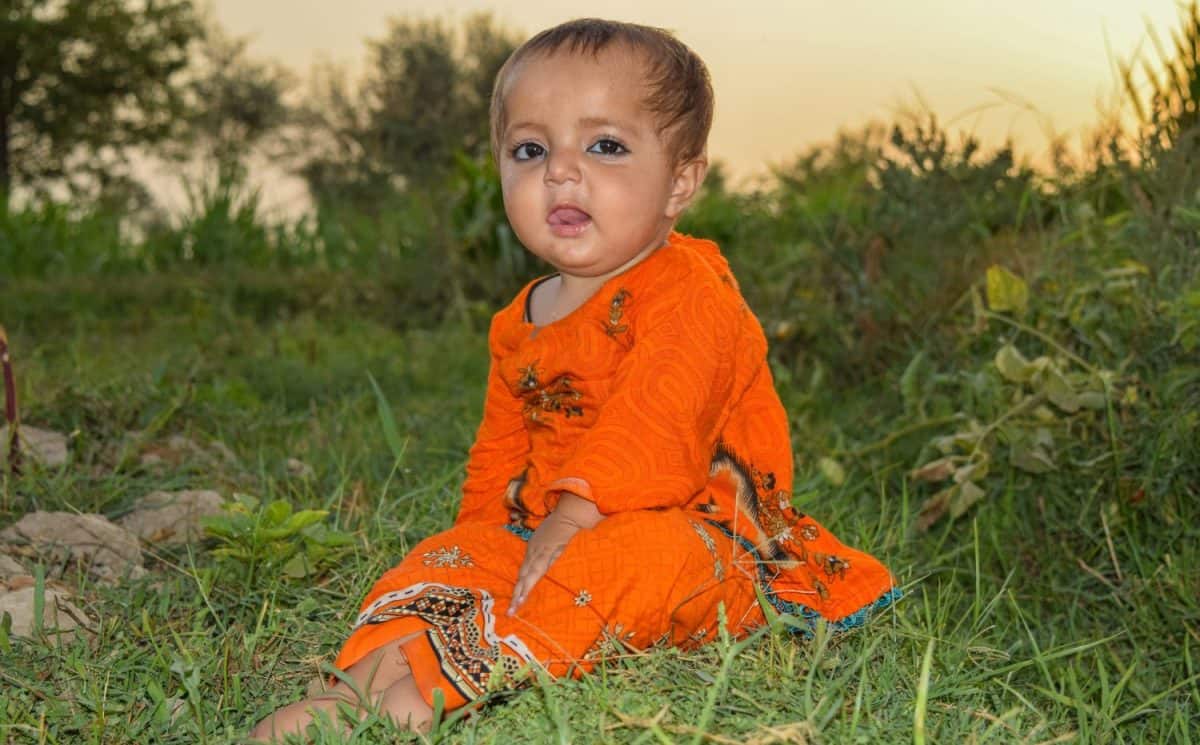 Portrait of 1 Year Pakistani baby girl. Pakistani baby girl playing in and eating against natural background. Pakistani kids. Pakistani 1 year baby. Asian baby girl. Happy kid. Village babies girl.