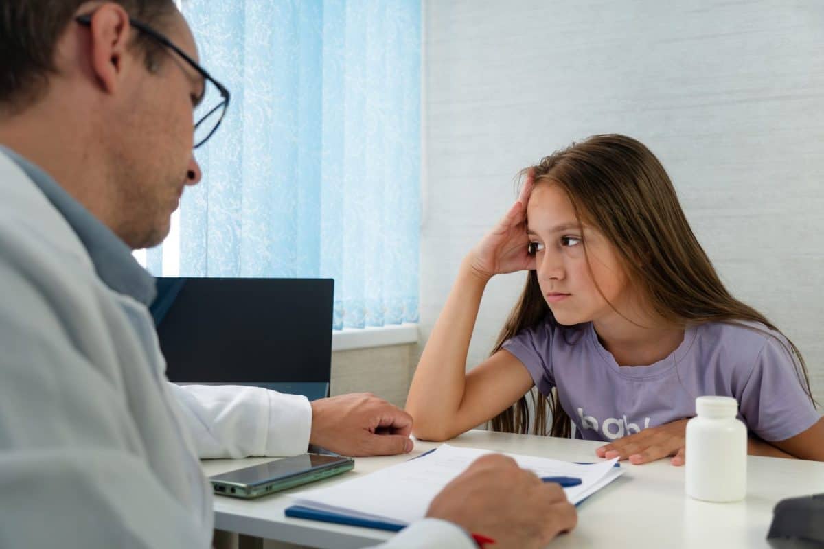 Concentrated attentive therapist professional consulting client in office, doctor explaining patient treatment details, gives recommendation to prevent, cure disease. child at pediatrician appointment