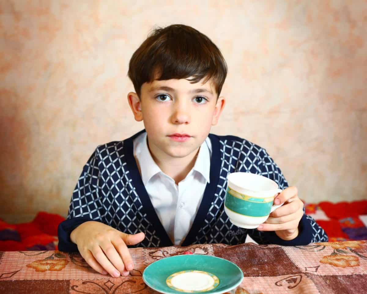 preteen handsome boy drink tea