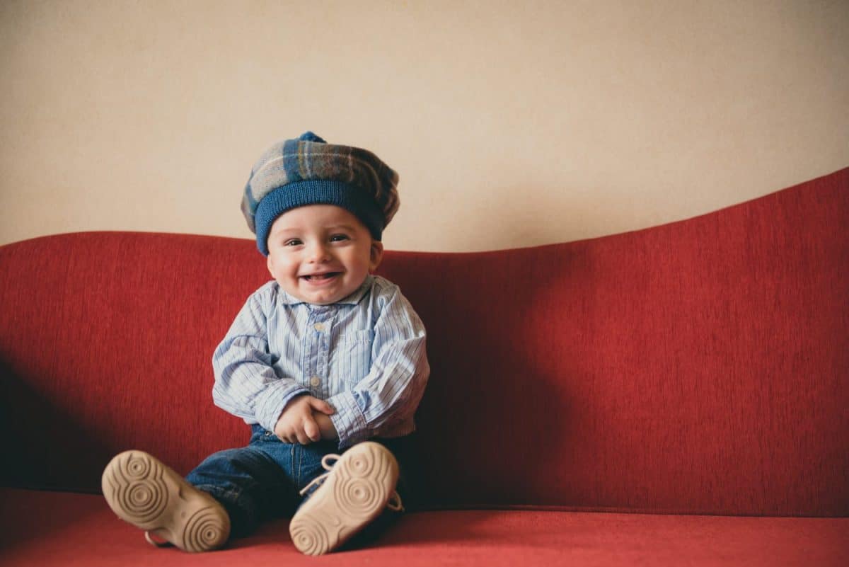 Beautiful baby boy on a red couch