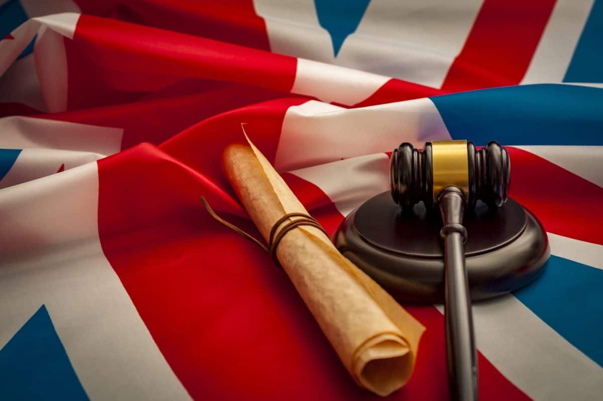 Union Jack, a gavel and the Magna Carta (a symbol for human rights, democracy and free speech) next to a gavel