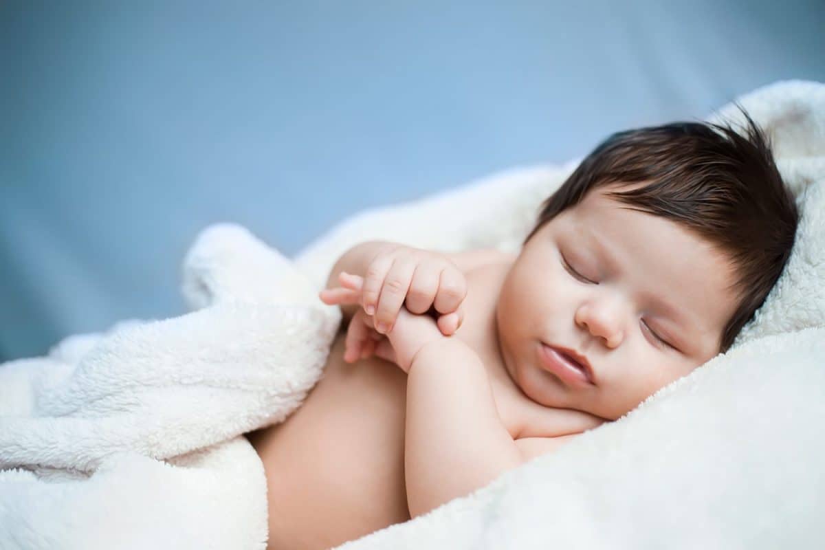 baby, newborn baby cute blue-eyed, dark hair, baby 2 months without clothes sleeps