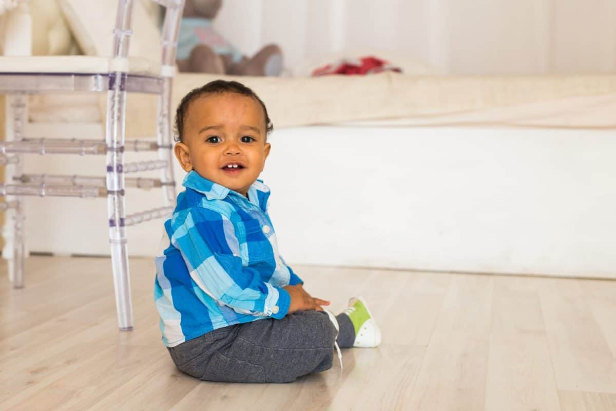 Full length portrait of a young mixed race boy sitting on the floor.