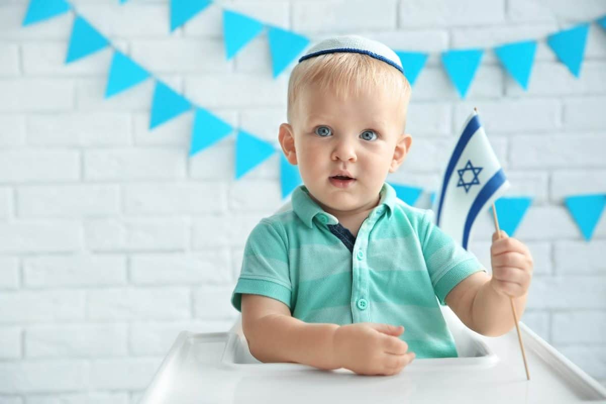 Jewish boy with flag at home