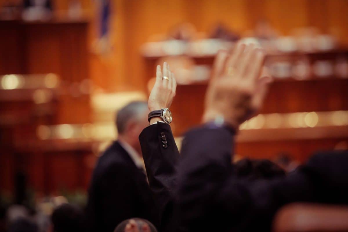 Member of Romanian Parliament is voting by raising his hand