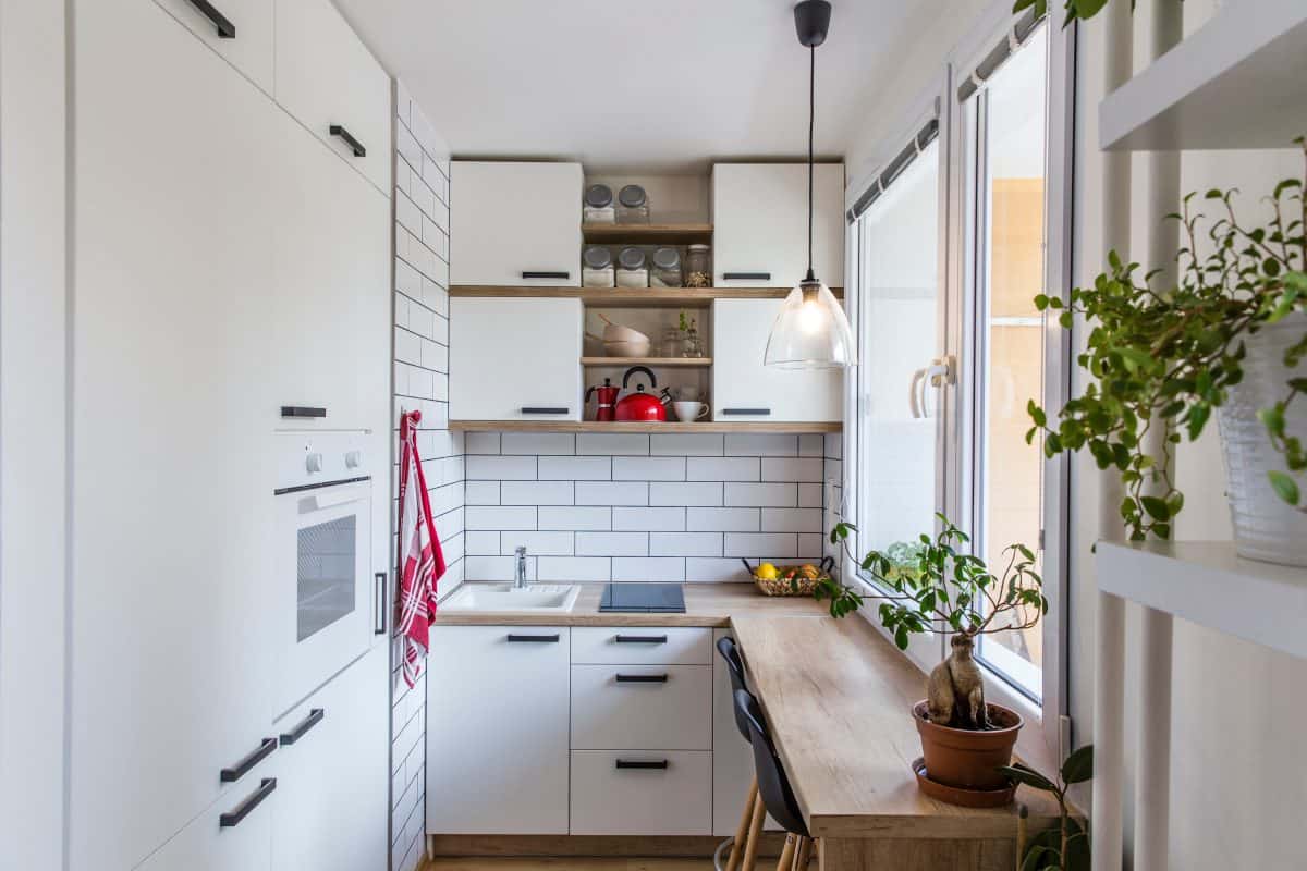 White kitchen with red components, cosy tiny home after the reconstruction in panel house