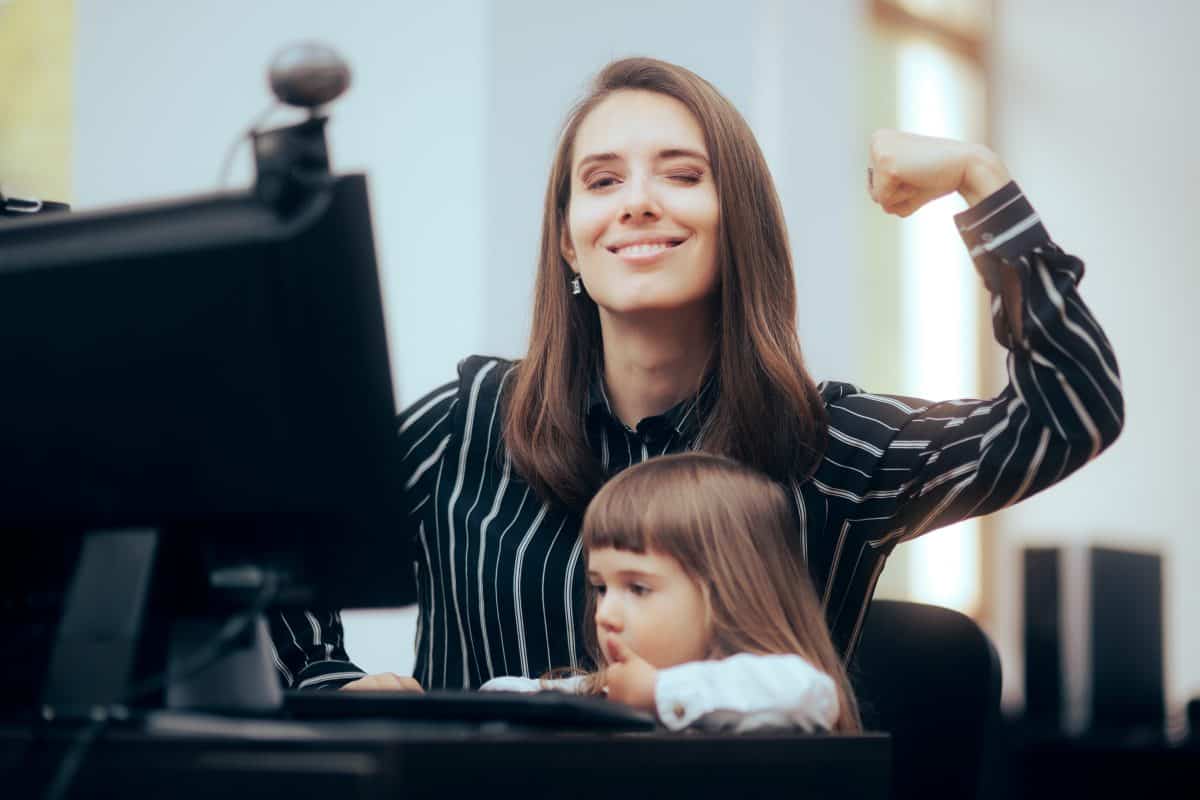 Strong Mom Flexing Her Muscles while Multitasking at Work Mother thriving managing her own business while taking care of her child