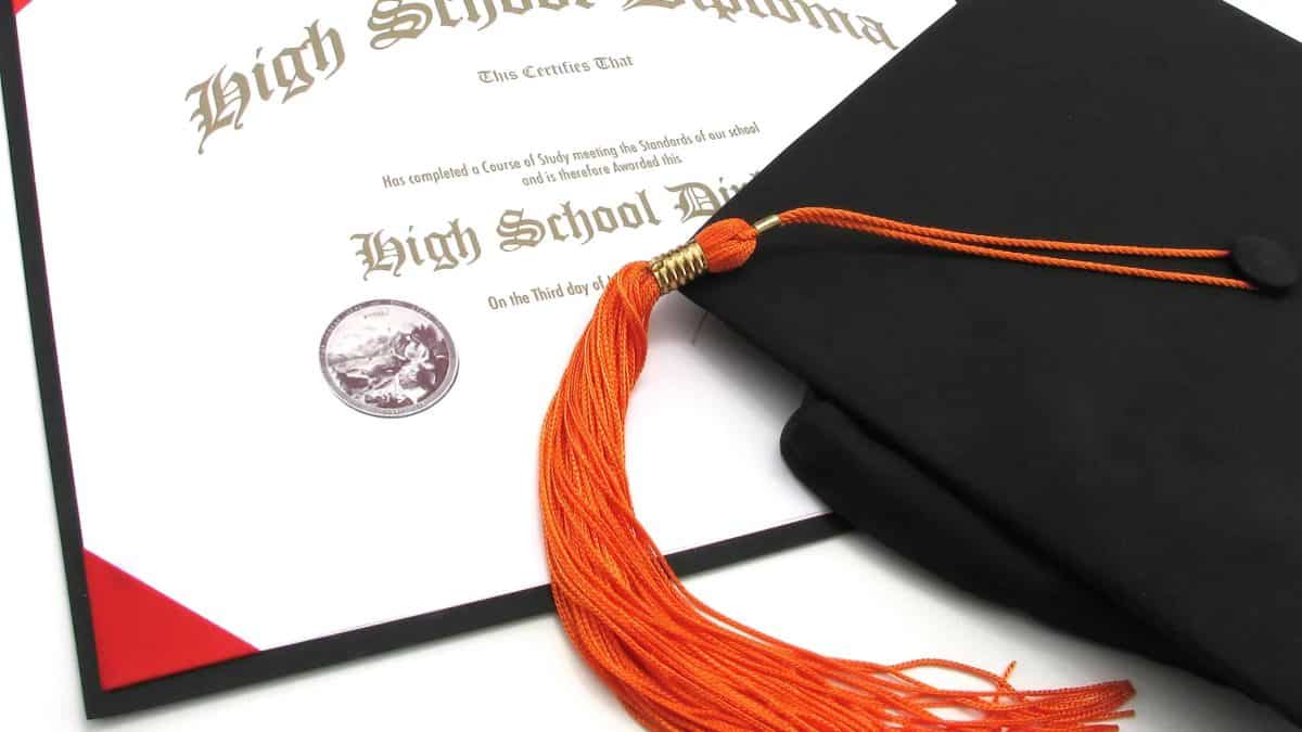 An isolated generic High School diploma with black cap and orange tassel