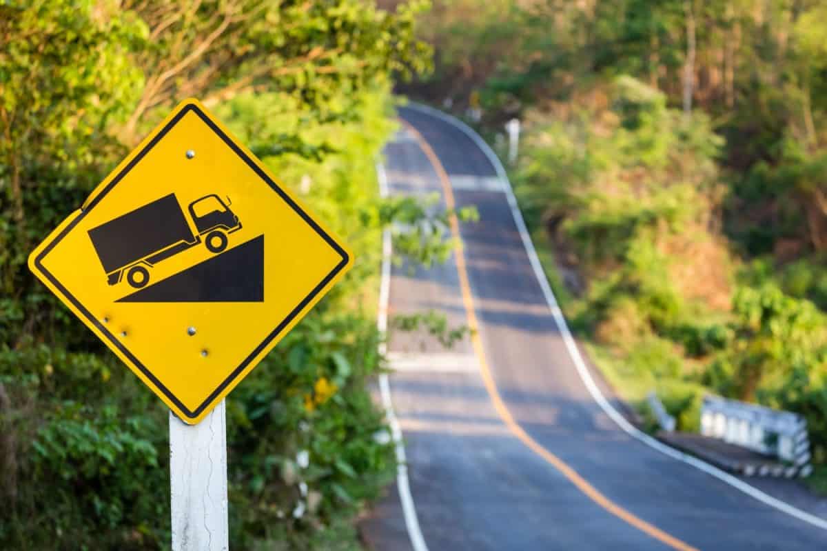 Steep grade traffic sign on the roadside, uphill asphalt road in countryside