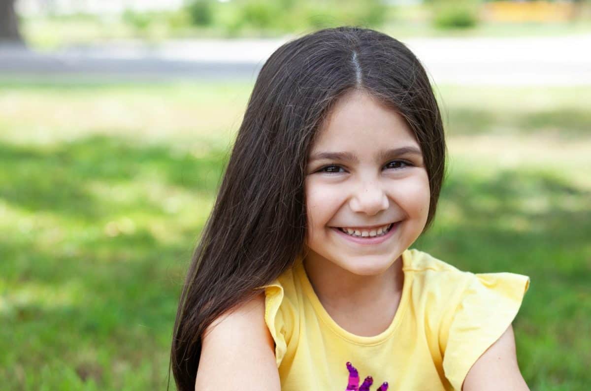 Portrait of a happy smiling child girl outdoor. Cute little girl playing in the park.