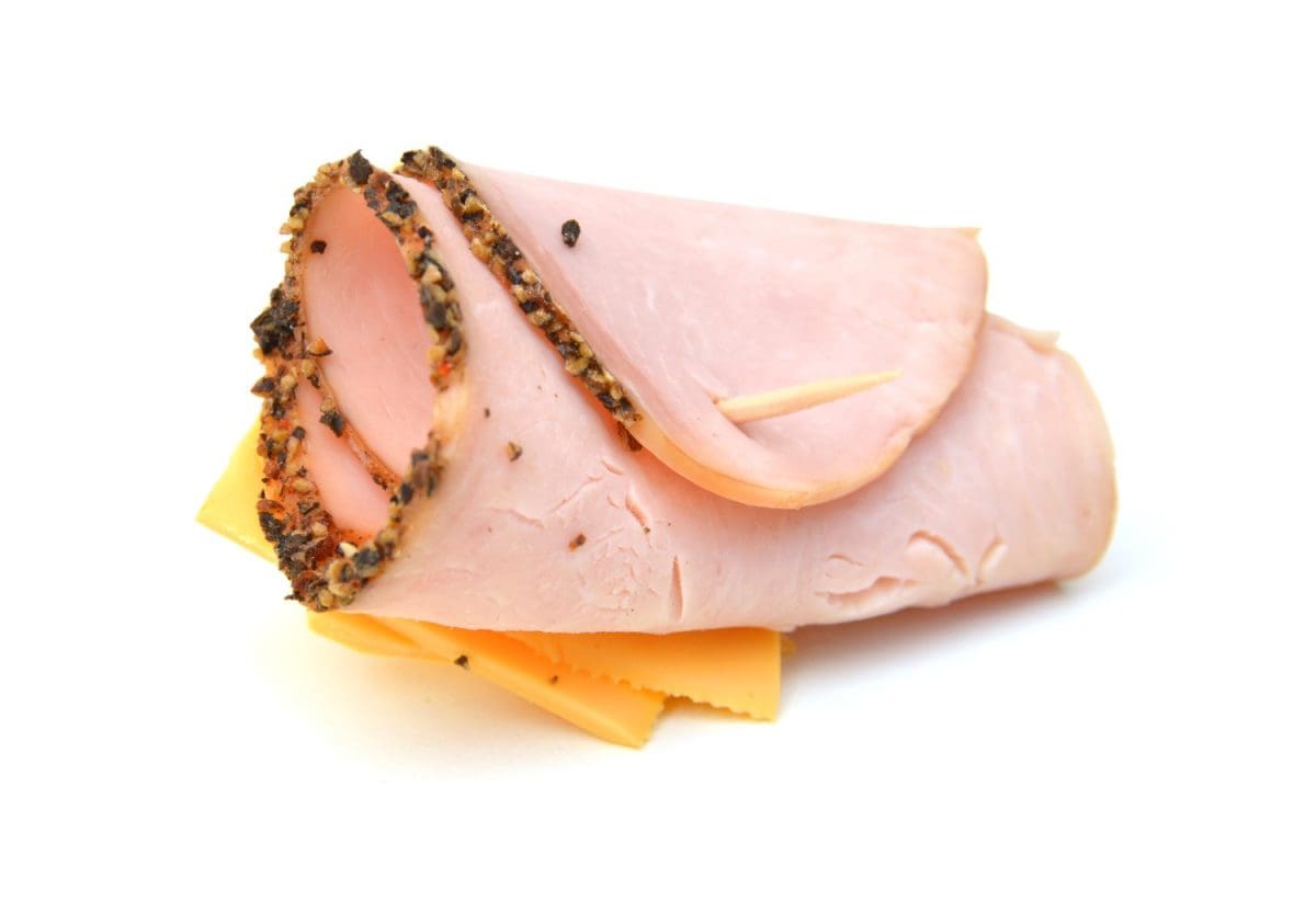 Delicious ham roll up cheese on white background