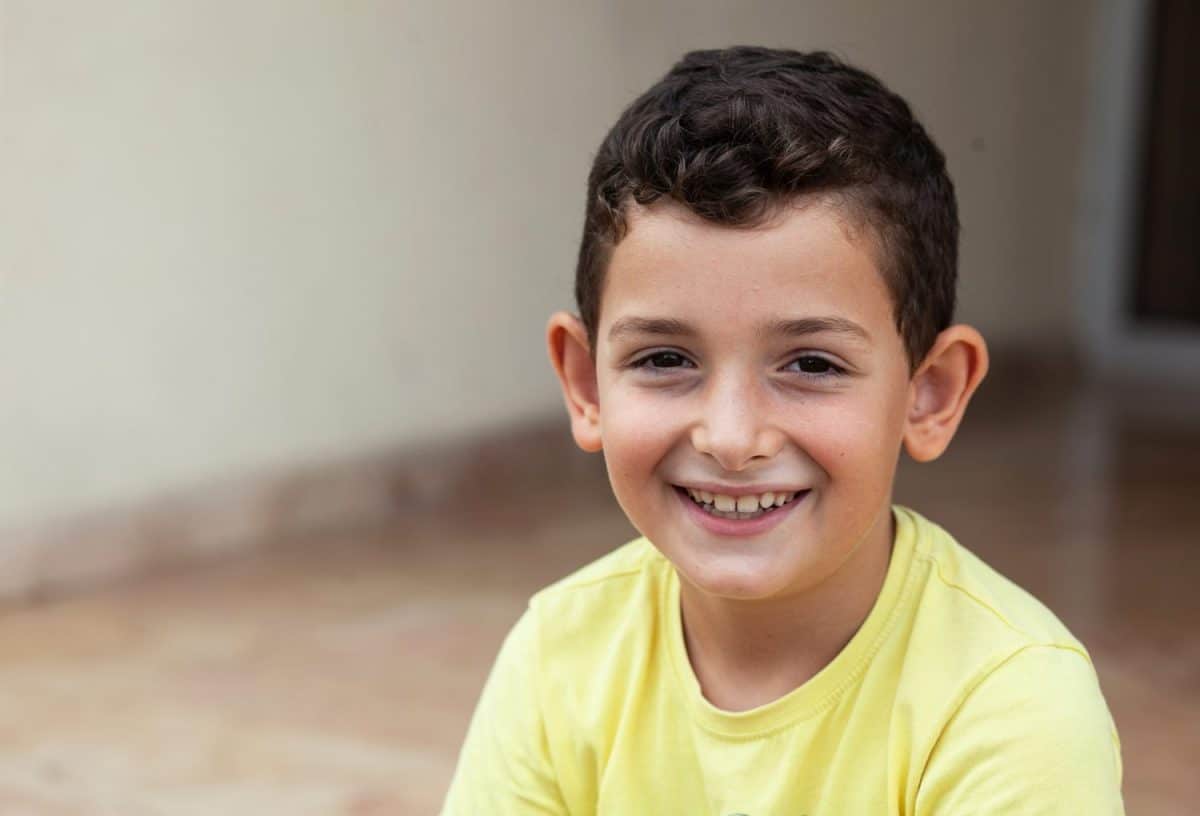 Portrait of happy smiling child boy outdoors. Concept of happy family or successful adoption or parenting.