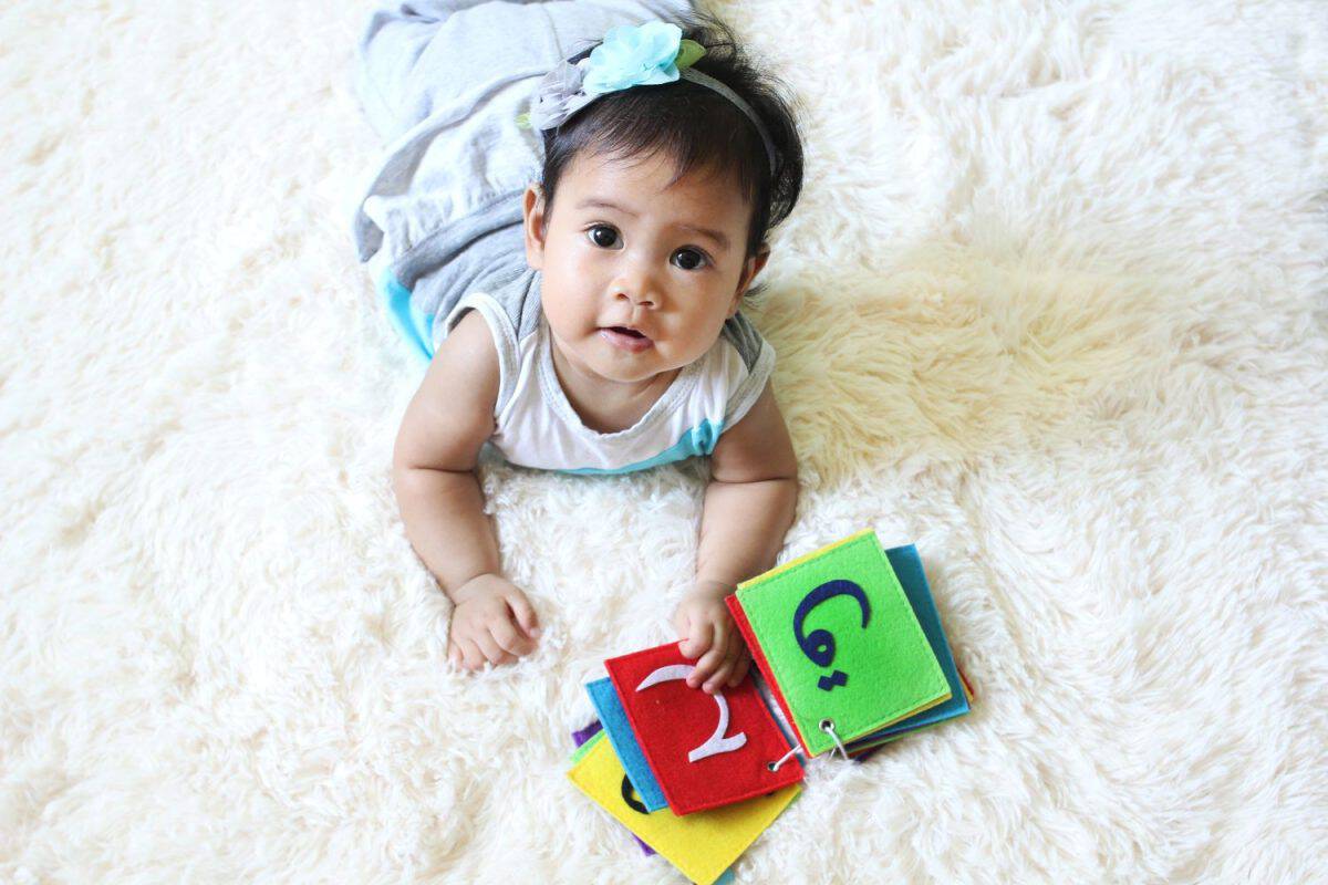 Seven months old baby girl with arabic alphabet.